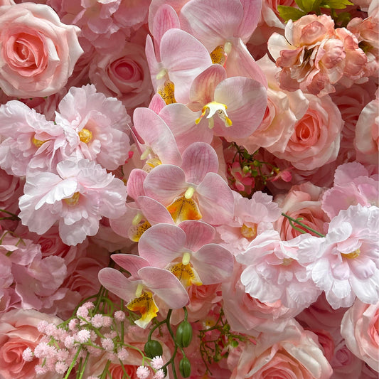 Close-up of pink and white flowers including roses and orchids.