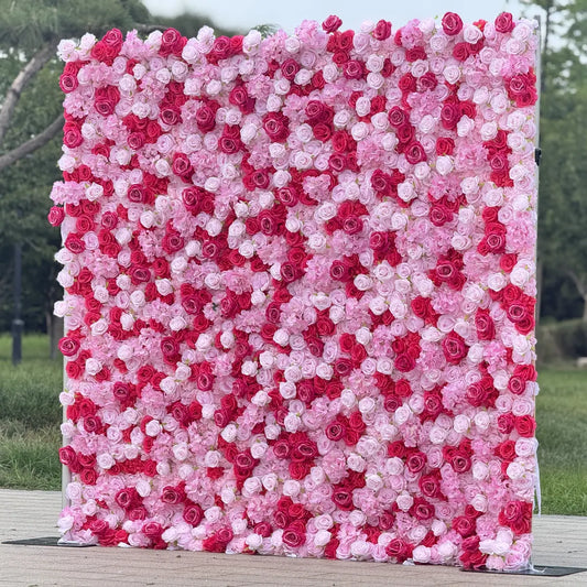 Floral wall made of pink and red flowers on a wooden platform with a blurred natural background