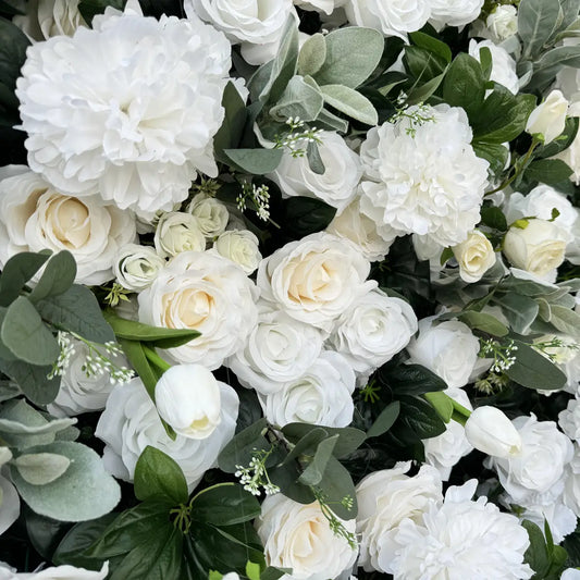 Handcrafted silk flowers used in white and green floral backdrop.