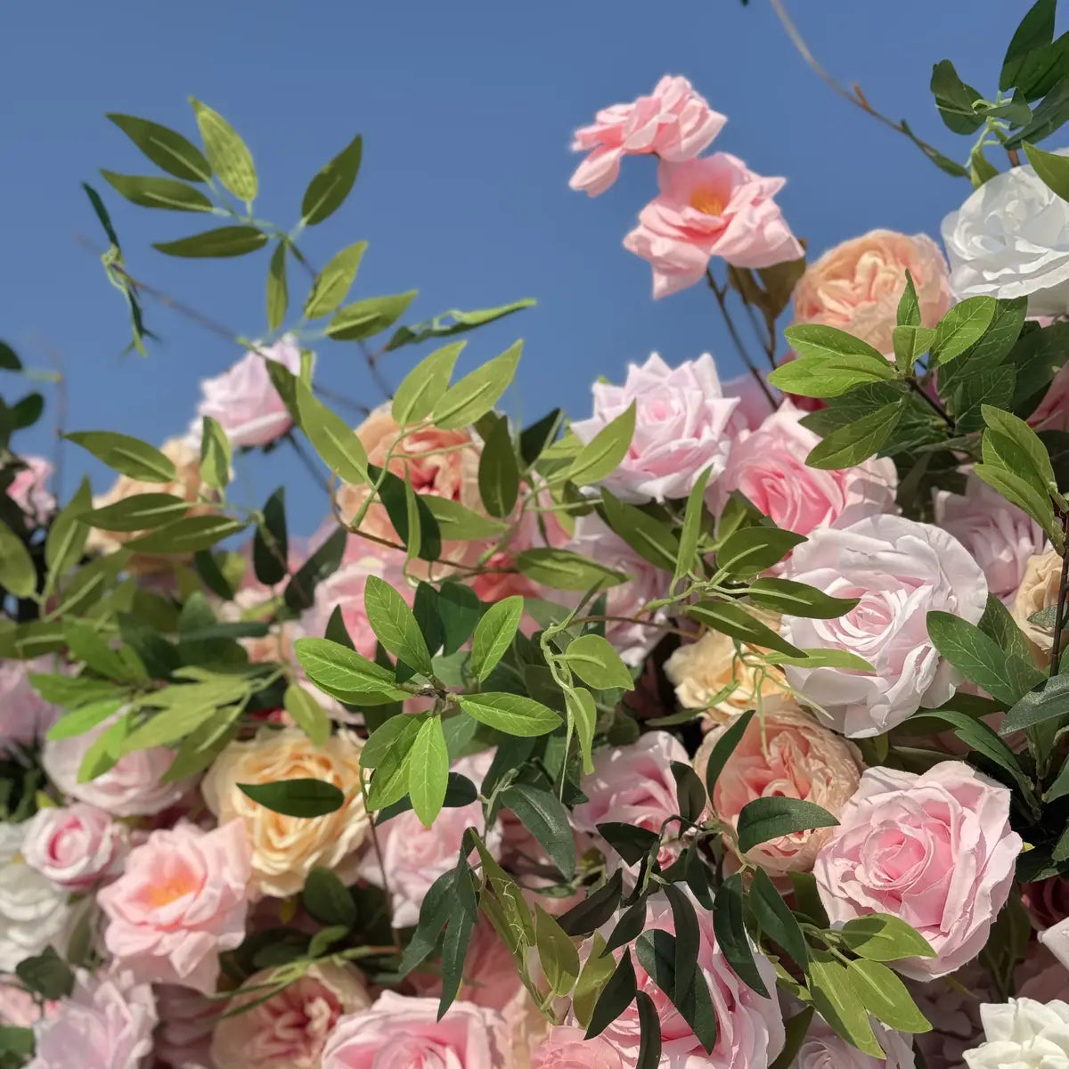 Bouquet of pink, white, and green flowers against a clear blue sky.