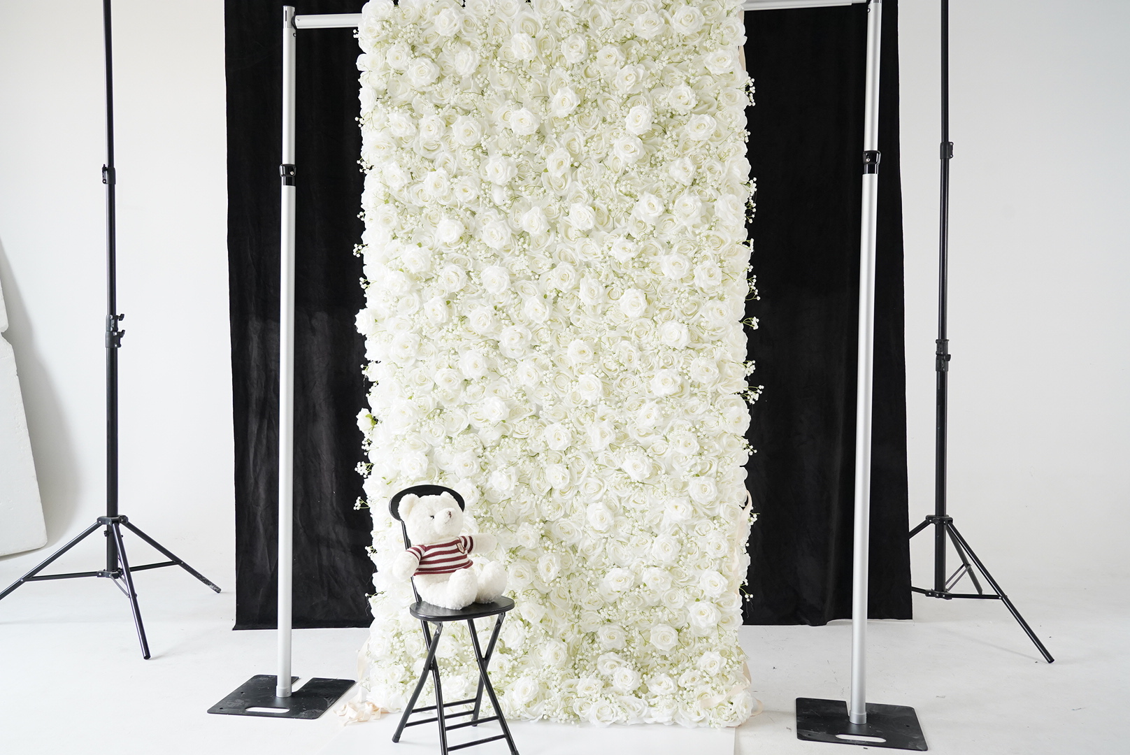 Placing a white bear in front of the baby breath pure white rose fabric flower wall.