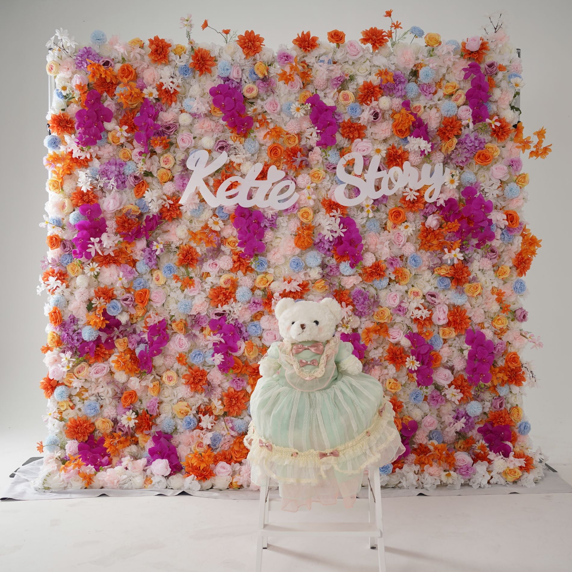 The bear is placed in front of the light pink flower wall to look lively and bright.