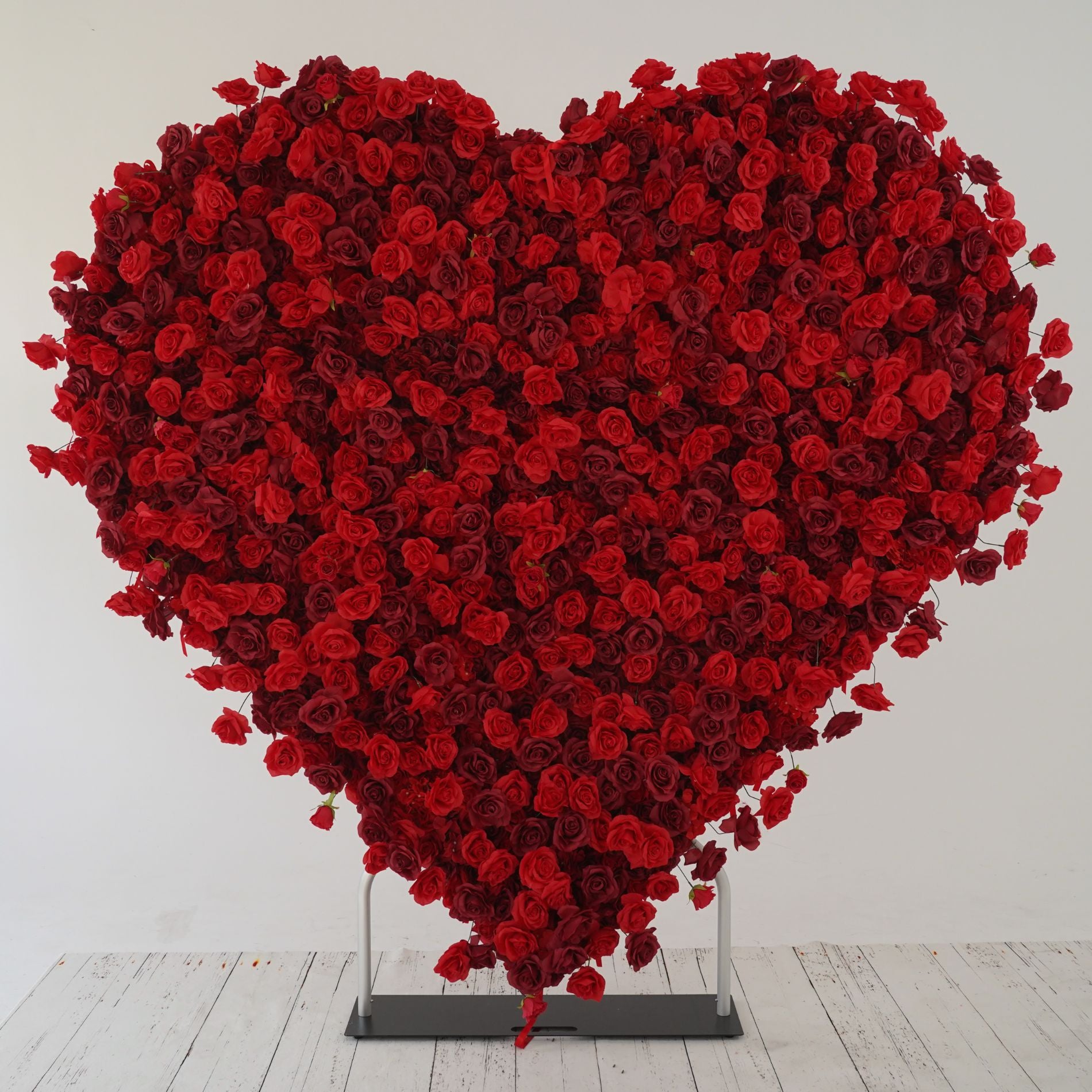 The heart shaped red rose flower wall looks warm and romantic.