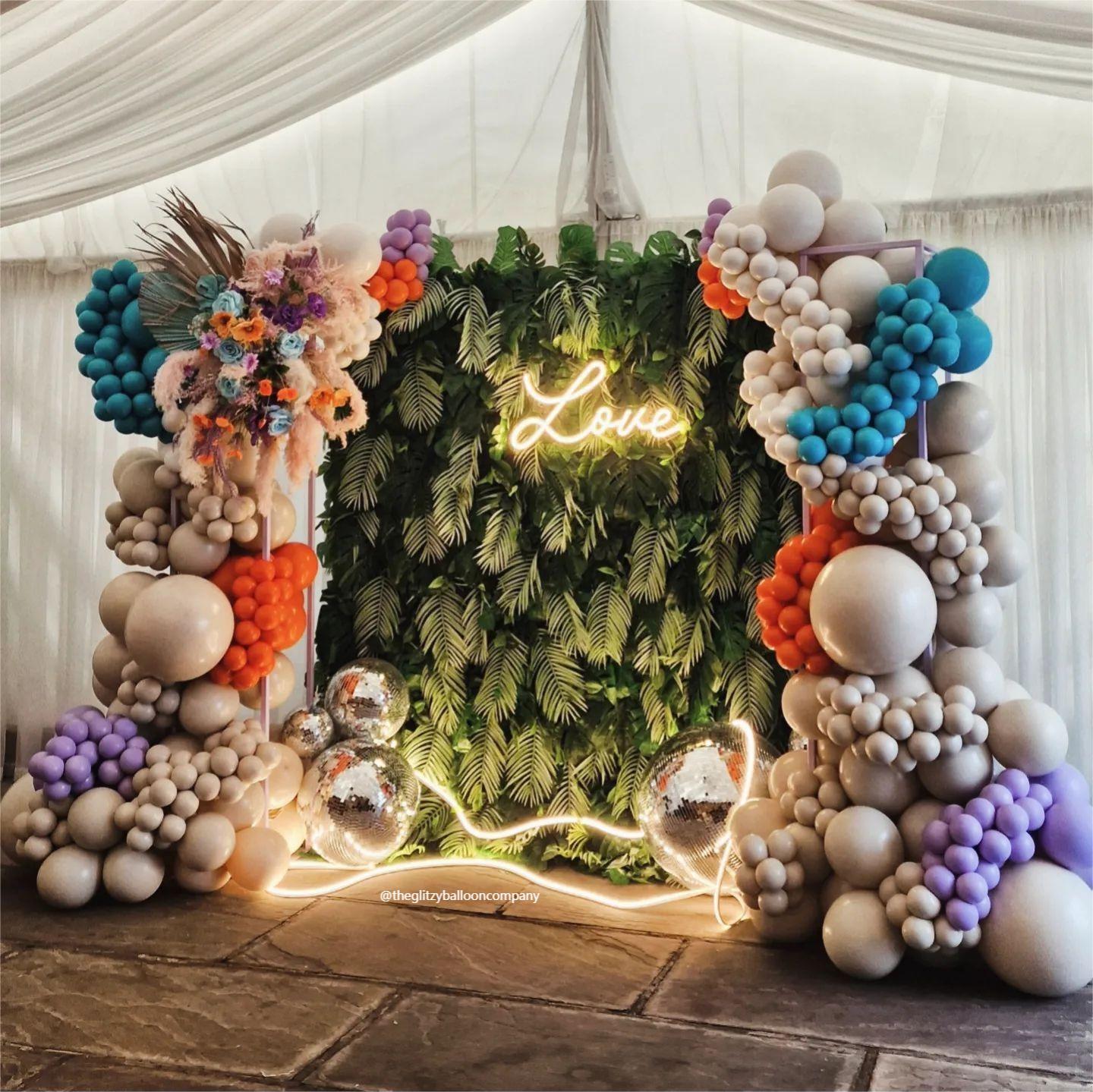 Balloons and LED lights make the rainforest fabric flower wall even more fantastic.